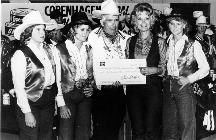 16-time World Champion cowboy Jim Shoulders awards the 1982 NIRA National Reserve Champion women’s team to New Mexico Junior College rodeo coach Sylvia Gann Mahoney (Benge) and team members Lori Wafer, Tami Noble, and LaRae Higgins - Courtesy Sylvia Gann Mahoney 